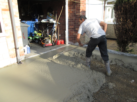Concrete being distributed across the driveway